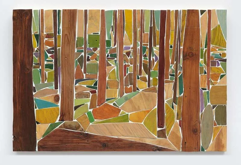 A relief of carved and joined wood fragments forming a dense forest of trees